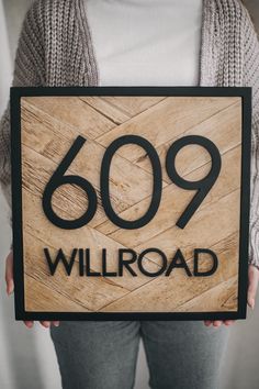 a woman holding up a sign that reads'609 willroad '