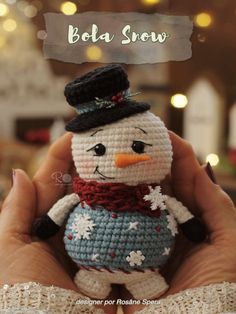 a hand holding a small crocheted snowman