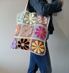 a woman carrying a crocheted granny bag with flowers on the front and sides