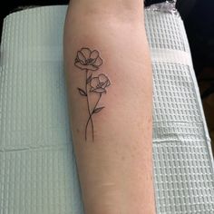 a single flower tattoo on the left arm