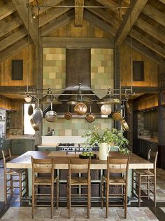 a kitchen with an oven, stove and table in it's center island surrounded by wooden chairs