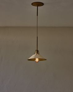 a light fixture hanging from the ceiling in a room with white walls and flooring