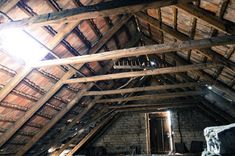 an attic with exposed wooden beams and brick walls