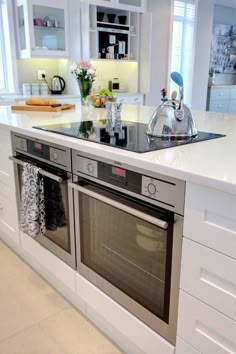 a kitchen with an oven, sink and counter top in the middle of the room