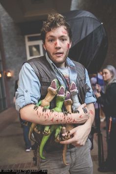 a man holding stuffed animals in his arms with blood all over it's face