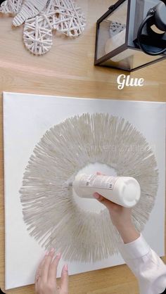 a person is using glue to decorate a piece of art