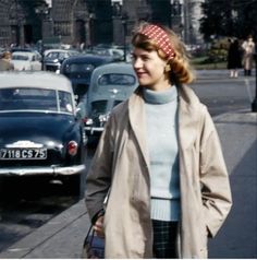 a woman walking down the street in front of cars