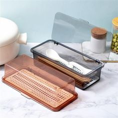 a kitchen utensil in a clear container on a marble counter