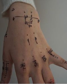 a person's hand with writing on it and symbols all over the palm area