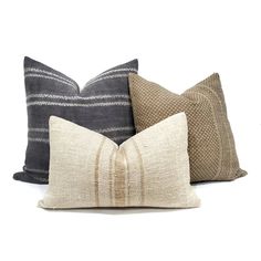 three pillows with different colors and patterns on the front, one in brown, one in white