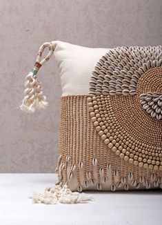 a decorative pillow with tassels and beads on the front is sitting on a table