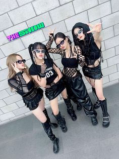 four young women in black outfits posing for a photo with their hands on their hips