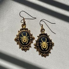 a pair of earrings with a bee on it