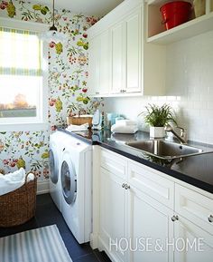 a washer and dryer in a small room with floral wallpaper on the walls