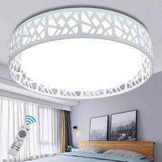 a bed room with a neatly made bed and a round light fixture above the bed