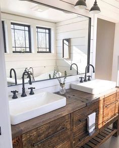 a bathroom with double sinks and two mirrors on the wall next to each other in front of a window