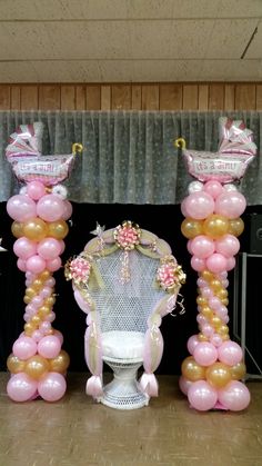 balloon columns with princess tiaras and balloons on them in front of a stage backdrop