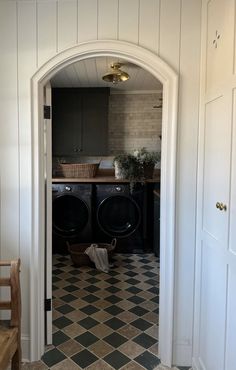 a washer and dryer sitting in a room next to each other on top of a checkered floor