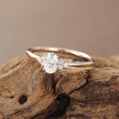 a close up of a diamond ring on top of a tree stump with a background