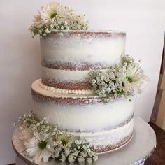 a three layer cake with flowers on top