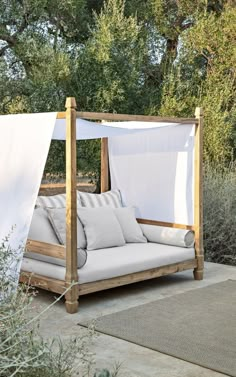 an outdoor day bed with canopy and pillows