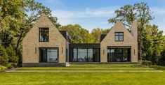 a large brick house in the middle of a lush green field