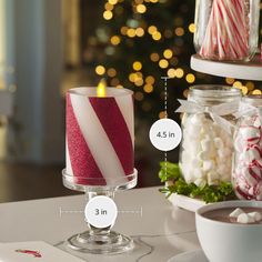 two candles sitting on top of a table next to candy canes