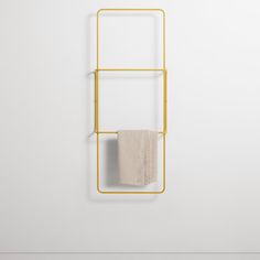 a towel rack on the wall next to a white wall with a gold frame and two towels hanging from it