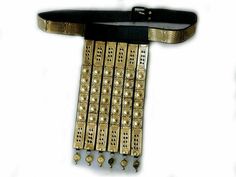 a gold belt with lots of small beads attached to the back of it, on a white background