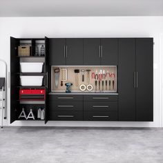 an organized garage with black cabinets and tools