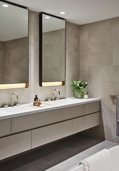 a bathroom with two sinks, mirrors and a bathtub in the middle of it