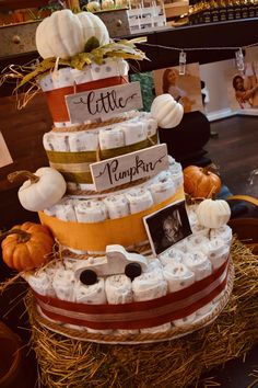 a diaper cake made to look like it is stacked with pumpkins and other items