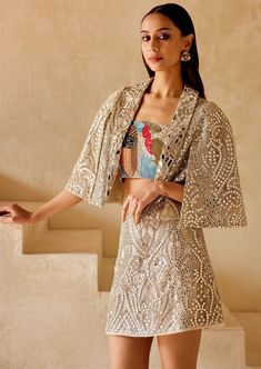 The skirt features a classic pencil silhouette adorned with intricate mirror embellishments. Luxury Festive Skirt Set With Mirror Work, Mirror Work Skirt, Luxury Bollywood Skirt With Mirror Work, Luxury Embellished Bollywood Skirt, Luxury Embroidered Bollywood Skirt, Rahul Khanna, Nyc Studio, Cape Sleeves, Nehru Jackets