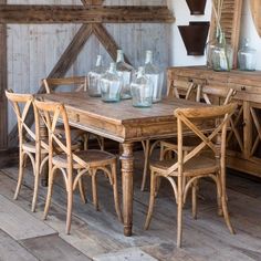 a wooden table with chairs and vases on it