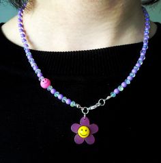 Clear and lilac glass beads with acrylic smiley face flower pendant.  Silver plated front fastener  Full length: 17.5 inches Flower Smiley Face, Flower Smiley, Face Flower, Polymer Beads, Stretch Ring, Glass Beaded Bracelets, Pendant Silver, Glass Bead Necklace, Beaded Stretch Bracelet