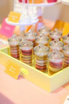 a yellow tray filled with small jars on top of a table