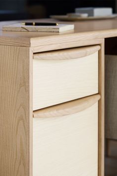 a wooden desk with two drawers and a remote control