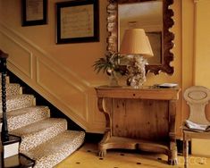 the stairs are lined with leopard print carpet and there is a mirror on the wall