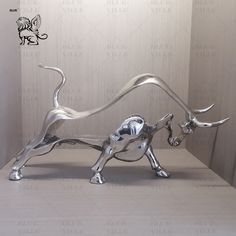 a silver bull statue sitting on top of a table