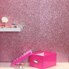 a pink box sitting on top of a counter next to a wall covered in glitter