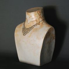 a white vase with a gold necklace on it