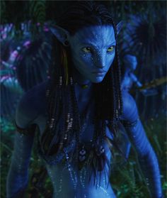 a woman with blue makeup and long braids in the jungle, surrounded by other people