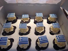 cupcakes with frosting and flag decorations in a box