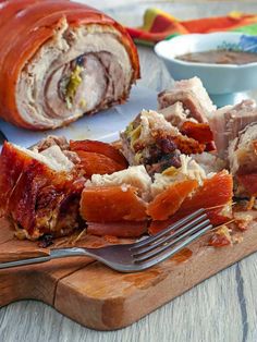 a wooden cutting board topped with meat and sauce