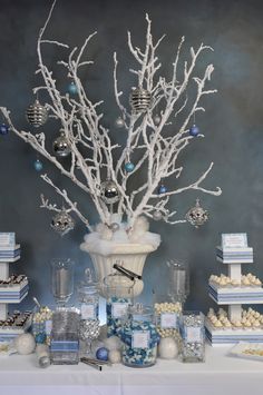 the table is decorated with silver and white decorations