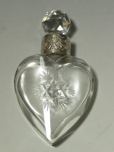 a clear glass bottle with a diamond on top