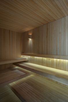 an empty sauna with wooden benches and lights