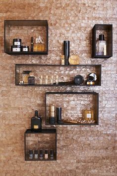 three shelves with various items on them against a brick wall in a spa or salon