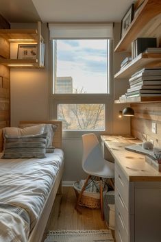 a small bedroom with a bed, desk and bookshelf in the corner next to a window