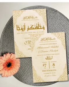 an arabic wedding card with a pink flower on the side and gold foilwork around it